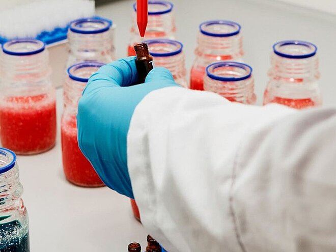 Hand holding a dropper in laboratory