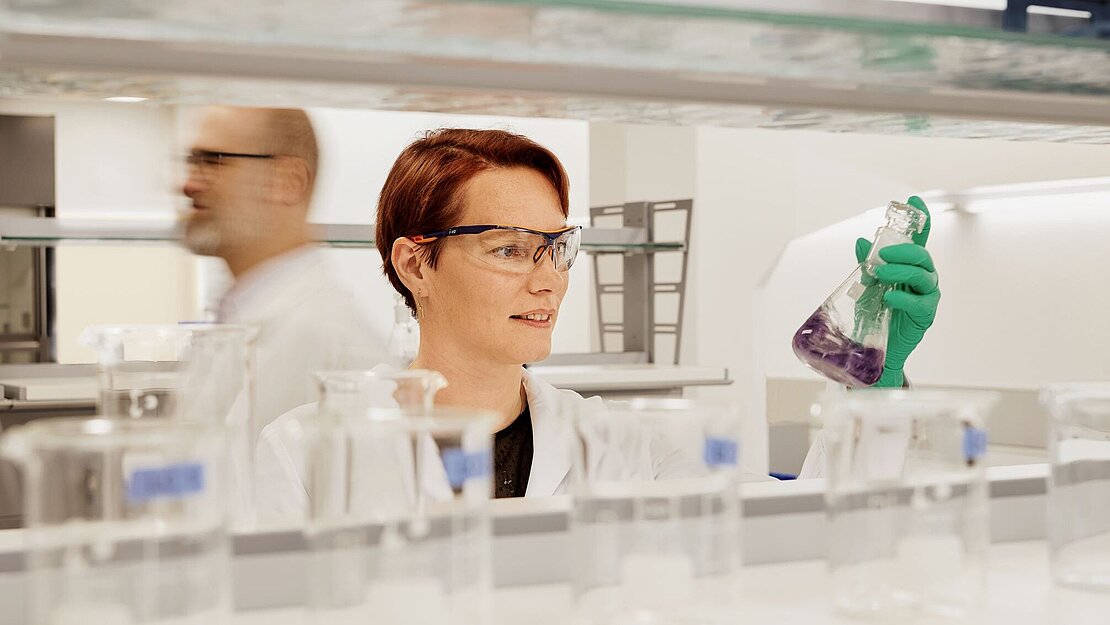 Scientist in a laboratory holding a laboratory flask