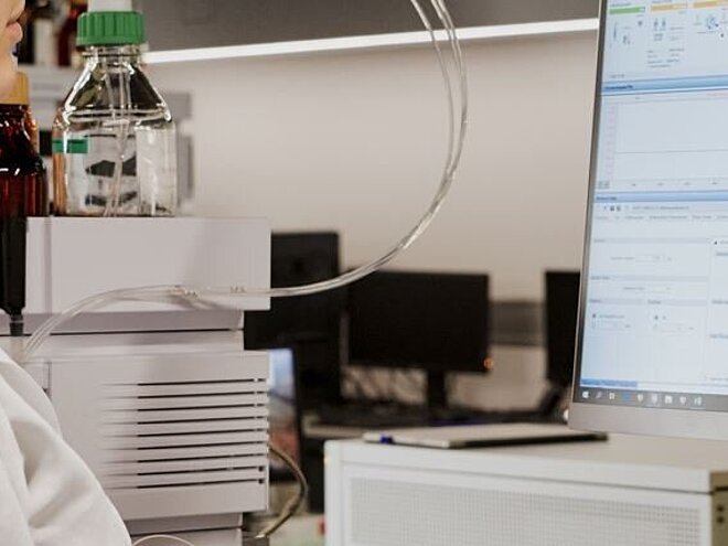 Laboratory assistant controlling test results on computer