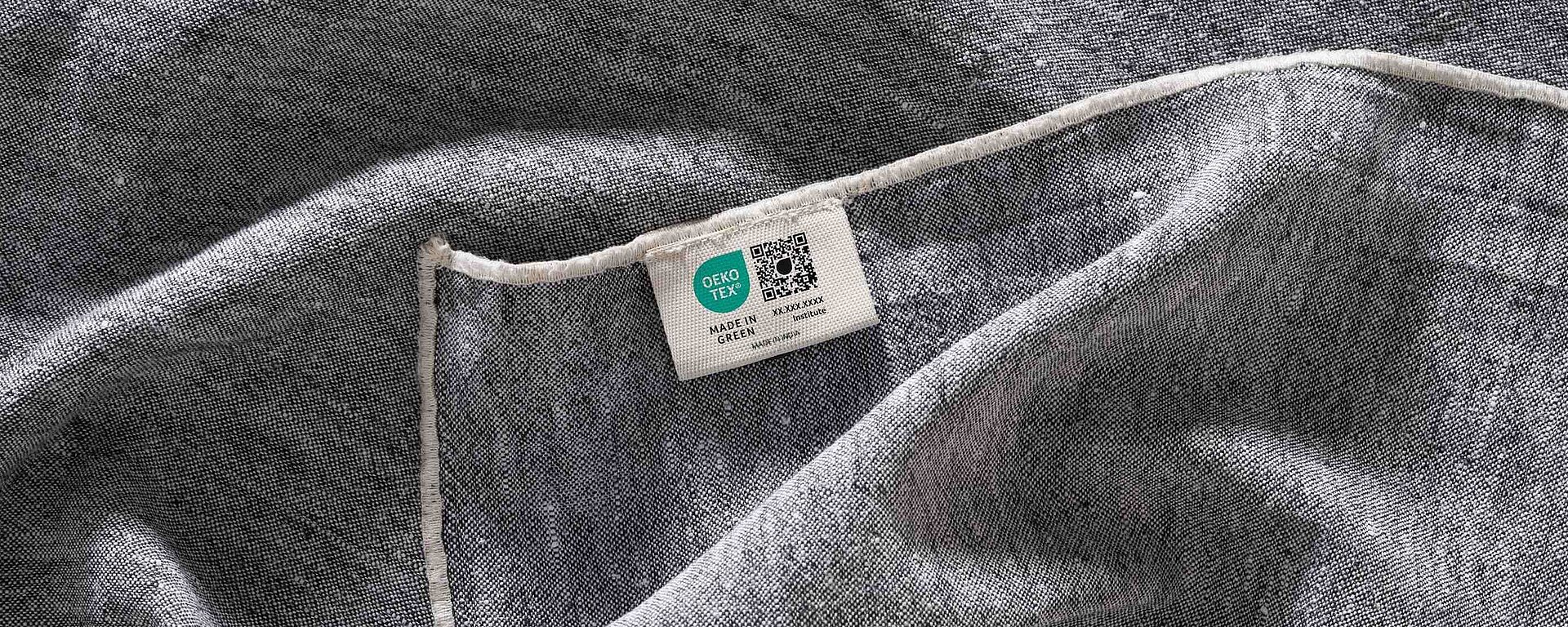 Grey fabric with a woven MADE IN GREEN label